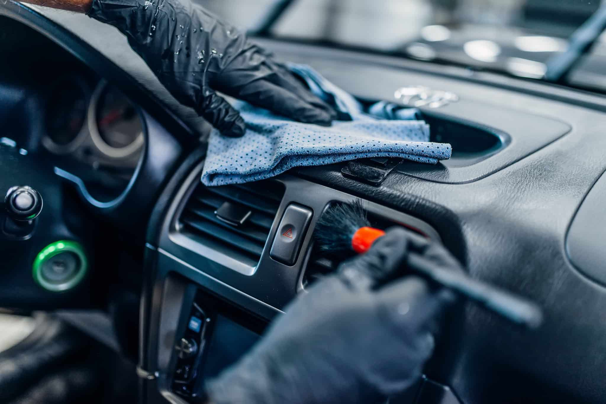 Detailer carefully cleaning a car dashboard